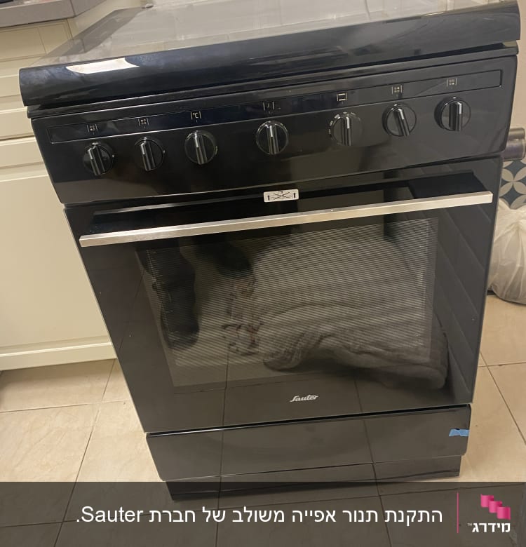 תנור גז שחור עם חמישה כפתורים עליונים